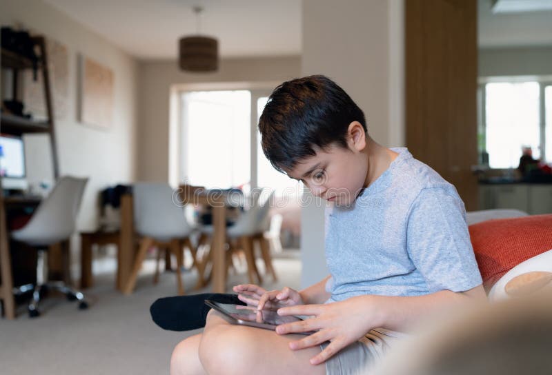 retrato menino jogando no celular enquanto espera por comida, garoto  sentado na cafeteria enviando texto para amigos, criança jogando jogo online  no celular. crianças com conceito de tecnologia 11248716 Foto de stock