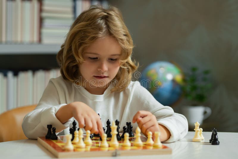 Escola de xadrez xadrez infantil concentrado jogo infantil inteligente  xadrez na biblioteca perto das estantes conceito educacional menino  pensando em xadrez o conceito de aprender e crescer crianças