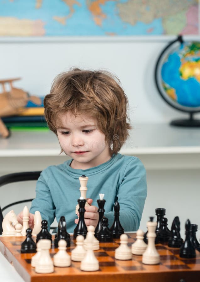 Escola de xadrez xadrez infantil concentrado jogo infantil inteligente  xadrez na biblioteca perto das estantes conceito educacional menino  pensando em xadrez o conceito de aprender e crescer crianças