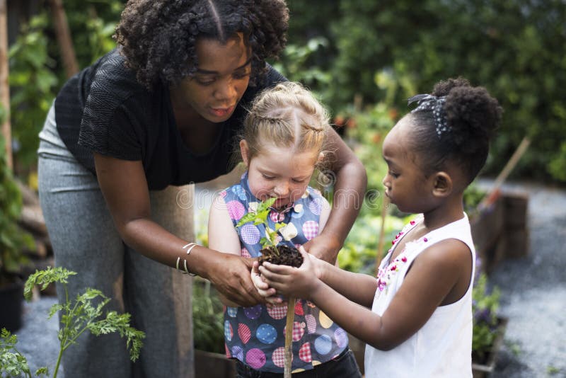 Escola do professor e das crianças que aprende a jardinagem da ecologia