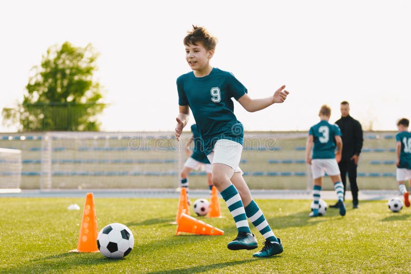 Escolares que asisten a la formación de fútbol en campo de césped imágenes de archivo libres de regalías