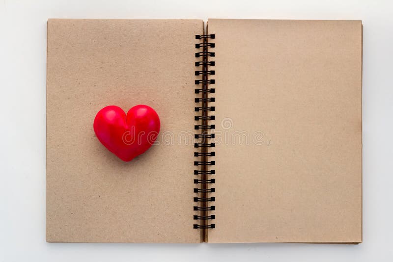 Esconda el cuaderno abierto con el corazón rojo imagen de archivo Esconda el cuaderno abierto con el corazón rojo imagen de archivo