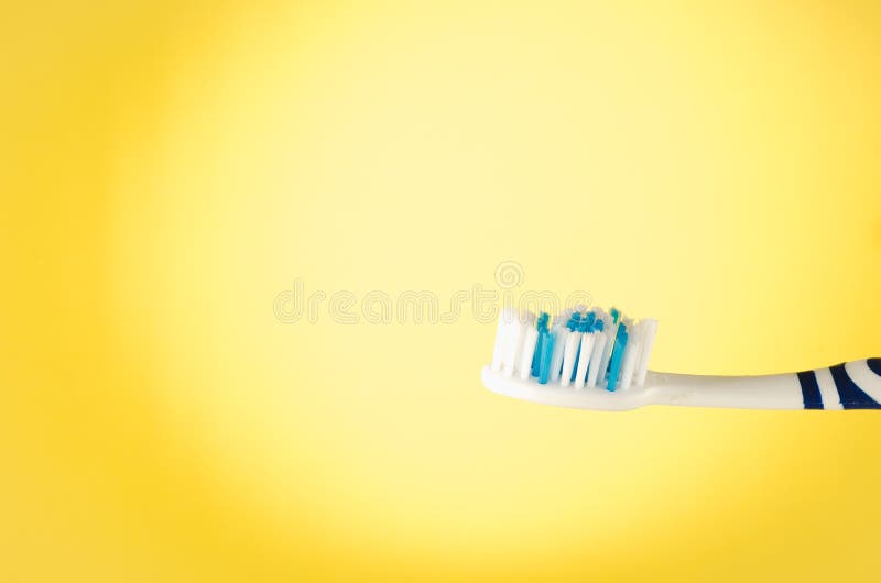 Escova de dentes úmida em um fundo amarelo com espaço da cópia foto de stock royalty free Escova de dentes úmida em um fundo amarelo com espaço da cópia foto de stock royalty free