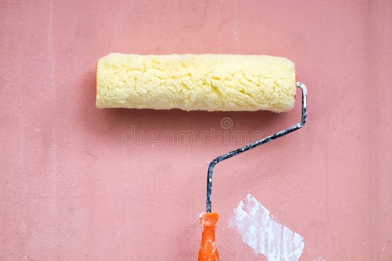 Escova de pintura do rolo no fundo vermelho rústico do Grunge imagem de stock royalty free Escova de pintura do rolo no fundo vermelho rústico do Grunge imagem de stock royalty free