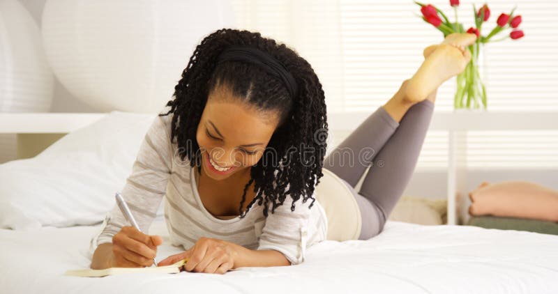 Escrita nova da mulher negra no jornal fotos de stock royalty free Escrita nova da mulher negra no jornal fotos de stock royalty free