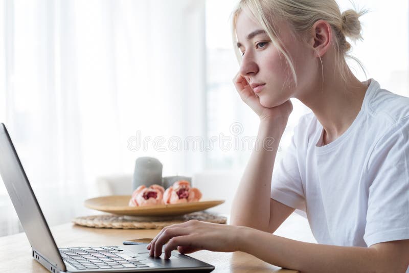 Pensive tired woman looking at laptop. writers block and no inspiration concept. Pensive tired woman looking at laptop. writers block and no inspiration concept.
