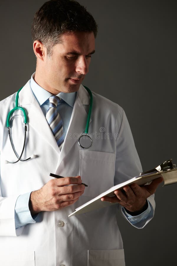 Escritura americana del doctor en su sujetapapeles imágenes de archivo libres de regalías Escritura americana del doctor en su sujetapapeles imágenes de archivo libres de regalías