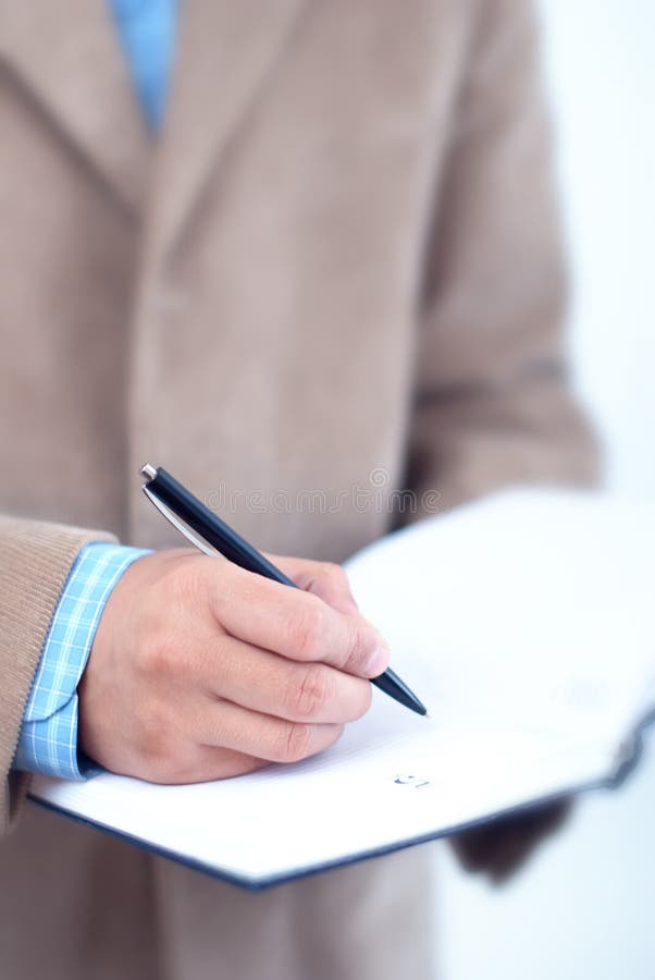 Escritura del hombre de negocios en agenda. foto de archivo Escritura del hombre de negocios en agenda. foto de archivo