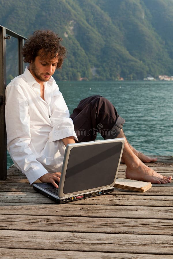 Escritura del hombre en la computadora portátil imágenes de archivo libres de regalías Escritura del hombre en la computadora portátil imágenes de archivo libres de regalías