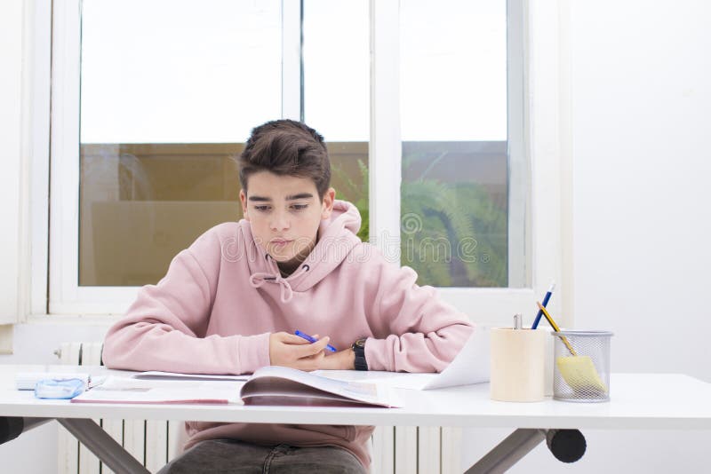 Escritura del niño en el escritorio del hogar o de la escuela fotos de archivo Escritura del niño en el escritorio del hogar o de la escuela fotos de archivo