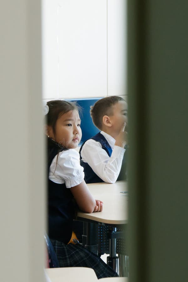 Escuela Puertas medio abiertas de la sala de clase Puede ser visto cómo la muchacha y el muchacho en uniforme escolar se sientan imagen de archivo Escuela Puertas medio abiertas de la sala de clase Puede ser visto cómo la muchacha y el muchacho en uniforme escolar se sientan imagen de archivo