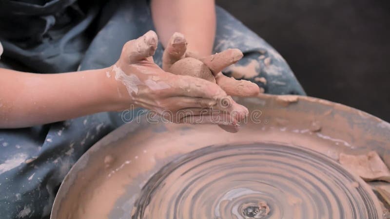 Mestre feminino trabalhando com argila crua na sala de cerâmica
