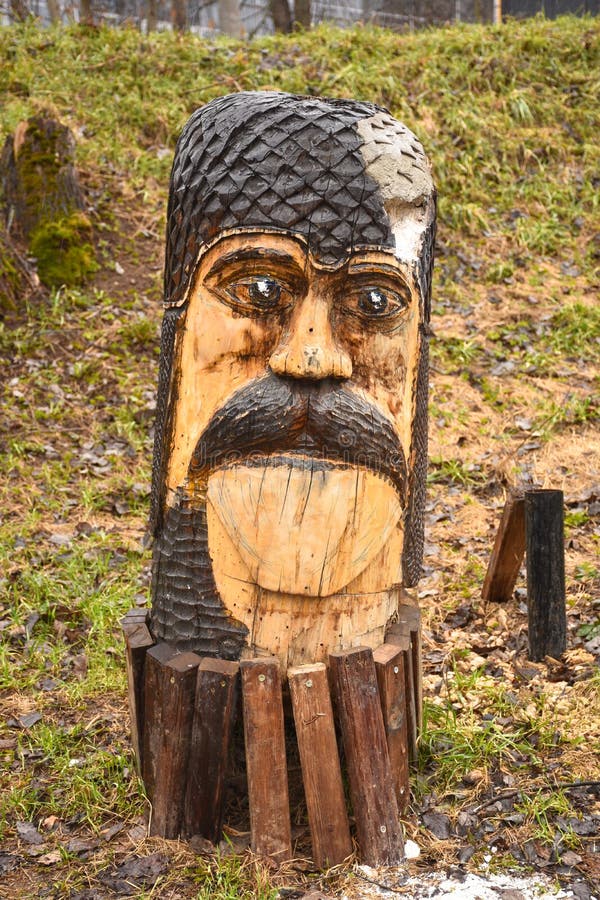 Escultura de madera en el parque bajo la forma de cara masculina con un bigote fotos de archivo Escultura de madera en el parque bajo la forma de cara masculina con un bigote fotos de archivo