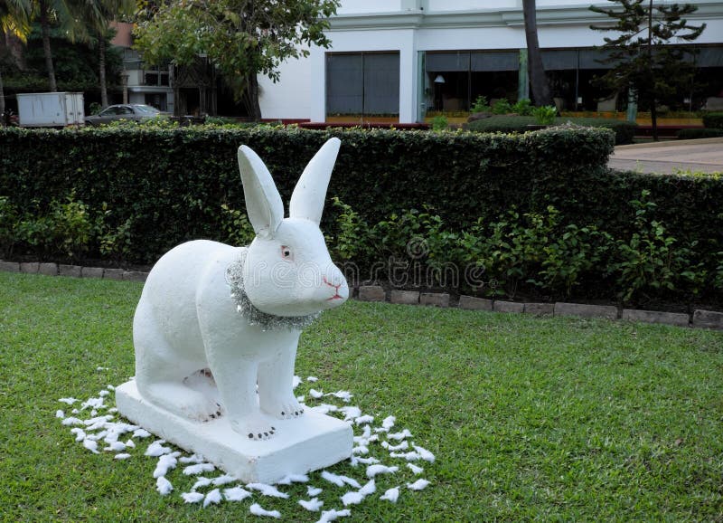 Escultura decorativa de un conejo, conejo blanco en un césped verde, decoración festiva del jardín imagen de archivo libre de regalías Escultura decorativa de un conejo, conejo blanco en un césped verde, decoración festiva del jardín imagen de archivo libre de regalías