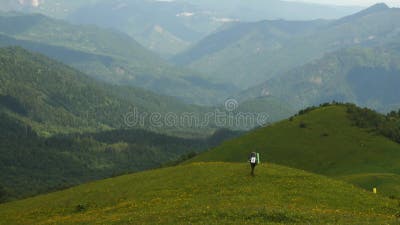 Escursionista Che Cammina Sull'erba in Montagna. Vista Posteriore. Davanti  a Lei C'è Un Bel Paesaggio Di Montagna. Persone Stock Footage - Video di  femmina, caucasico: 253478782