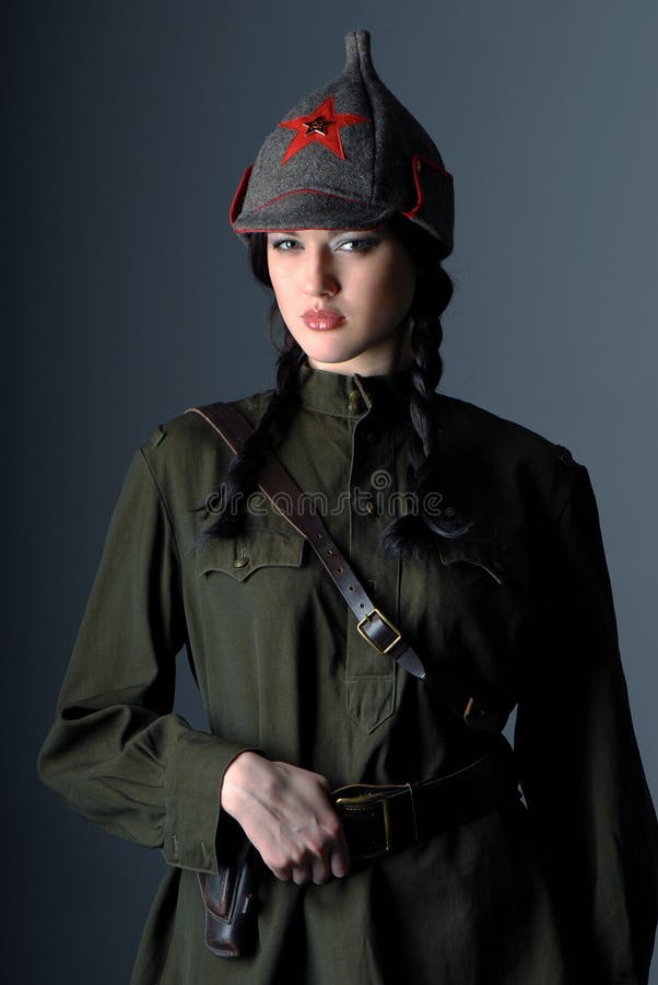Portrait of a young beautiful girl in the uniform of the red army on dark gray background. Portrait of a young beautiful girl in the uniform of the red army on dark gray background