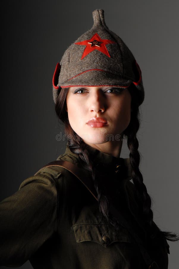 Portrait of a young beautiful girl in the uniform of the red army on dark gray background. Portrait of a young beautiful girl in the uniform of the red army on dark gray background