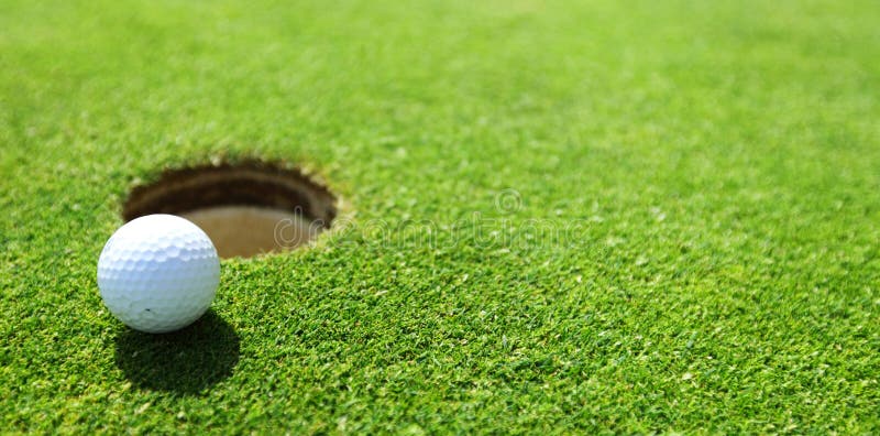 Golf ball on lip of cup close up. Golf ball on lip of cup close up