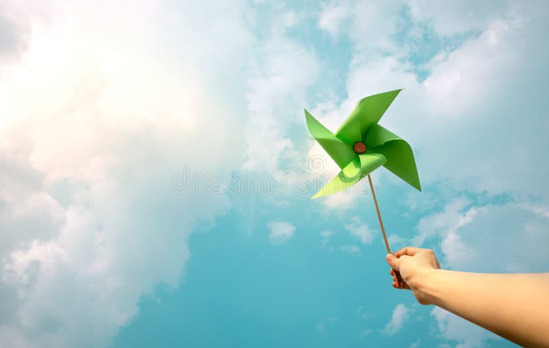 ESG and Clean Energy Concept. Hand Raise up a Wind Turbine Paper into the Sky. Decrease Carbon and Produce a Green Power. World royalty free stock photo