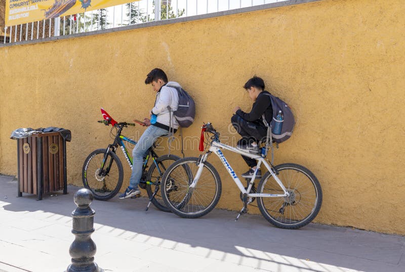 eskisehir-turkey-april-two-male-students-leaning-wall-sitting-relaxing-bike-checking-their-mobile-phones-148205139.jpg