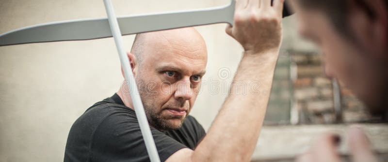 Eskrima et instructeur de kapap démontre la technique de combat d'arme de machette photo stock Eskrima et instructeur de kapap démontre la technique de combat d'arme de machette photo stock