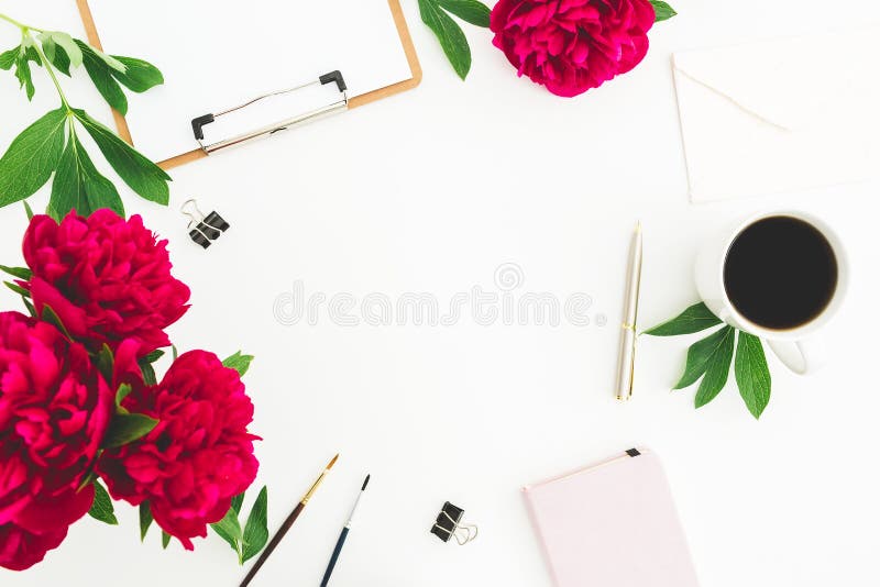 Espacio de la copia del Blogger o del freelancer con el tablero, el cuaderno, las flores de la peonía y la taza de café en el fon foto de archivo Espacio de la copia del Blogger o del freelancer con el tablero, el cuaderno, las flores de la peonía y la taza de café en el fon foto de archivo