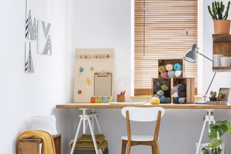 Espacio de trabajo creativo con muebles escandinavos, de madera, paredes blancas y herramientas de costura en un interior moderno imagenes de archivo Espacio de trabajo creativo con muebles escandinavos, de madera, paredes blancas y herramientas de costura en un interior moderno imagenes de archivo