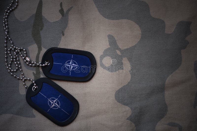 Espacio en blanco del ejército, placa de identificación con la bandera de la OTAN en el fondo de color caqui de la textura Concepto militar