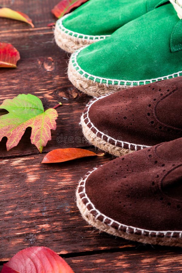 Espadrilles de bottes de suède de Brown et d'homme vert sur en bois images libres de droits Espadrilles de bottes de suède de Brown et d'homme vert sur en bois images libres de droits