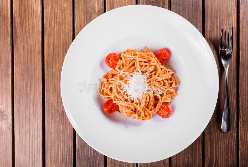 Espaguetes da massa com azeite, queijo, ervas e tomates no fundo de madeira, culinária italiana imagens de stock royalty free Espaguetes da massa com azeite, queijo, ervas e tomates no fundo de madeira, culinária italiana imagens de stock royalty free