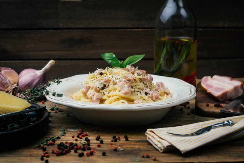 Espaguetis Carbonara Carbonara del alla de las pastas con una salsa cremosa, un tocino y una pimienta en una placa blanca imagenes de archivo Espaguetis Carbonara Carbonara del alla de las pastas con una salsa cremosa, un tocino y una pimienta en una placa blanca imagenes de archivo