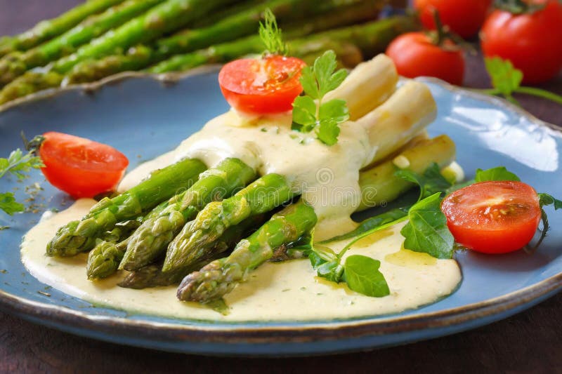 green asparagus with cream sauce, on a plate with tomatoes and parsley. green asparagus with cream sauce, on a plate with tomatoes and parsley