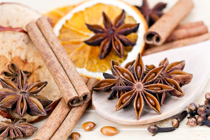 Closeup of a decorative, fragrant display of Christmas spices including cinnamon sticks, orange slices, dry apple and star anise. Closeup of a decorative, fragrant display of Christmas spices including cinnamon sticks, orange slices, dry apple and star anise.