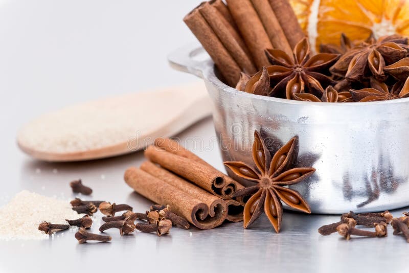 Closeup of a decorative, fragrant display of Christmas spices including cinnamon sticks, orange slices, star anise, cloves and sugar. Closeup of a decorative, fragrant display of Christmas spices including cinnamon sticks, orange slices, star anise, cloves and sugar