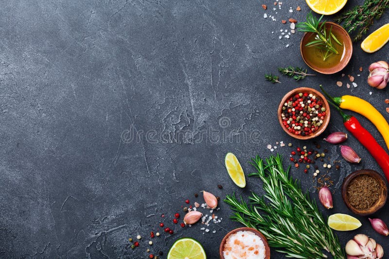 Especiarias e ervas diferentes na opinião de tampo da mesa de pedra preta Ingredientes para cozinhar Fundo do alimento