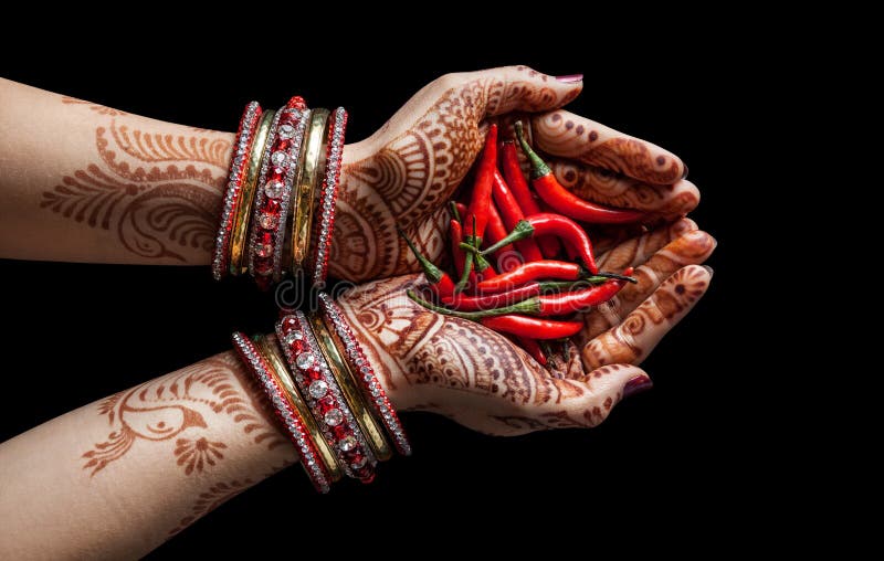 Woman hands with henna holding red chili isolated on black background with clipping path. Woman hands with henna holding red chili isolated on black background with clipping path