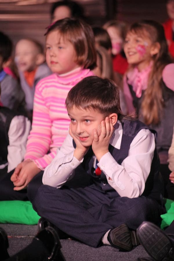 Espectadores de teatro jovenes niños que miran entusiasta el teatro Smeshariki del espectáculo de marionetas de la Navidad de los imagen de archivo Espectadores de teatro jovenes niños que miran entusiasta el teatro Smeshariki del espectáculo de marionetas de la Navidad de los imagen de archivo
