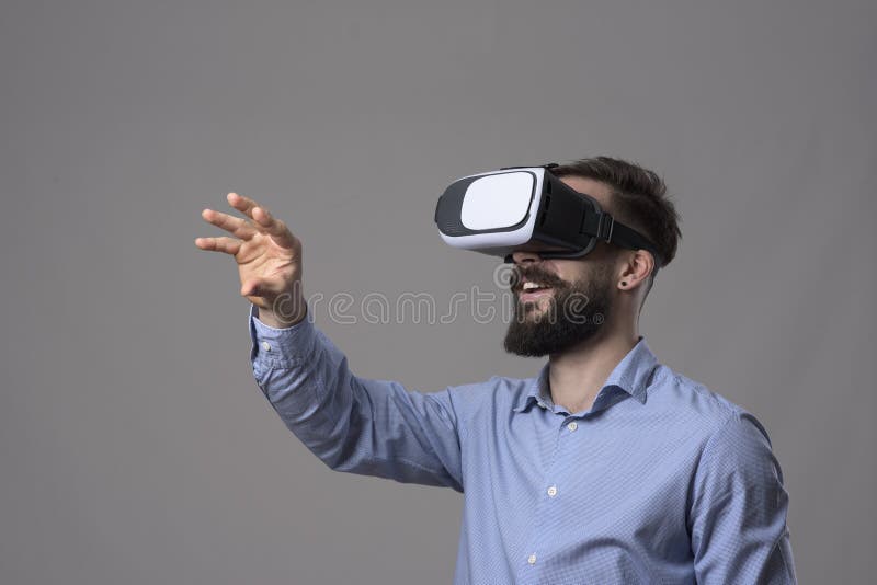Esperienza stupefacente di realtà virtuale nei giovani vetri del vr dell'uomo di affari e gesturing schermo d'uso a mano fotografia stock Esperienza stupefacente di realtà virtuale nei giovani vetri del vr dell'uomo di affari e gesturing schermo d'uso a mano fotografia stock
