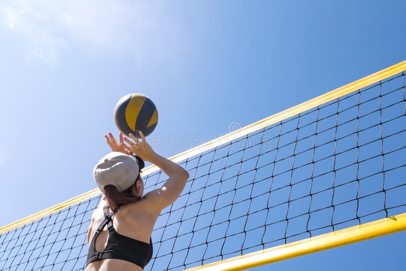 Imagem de pessoas jogando vôlei na praia.