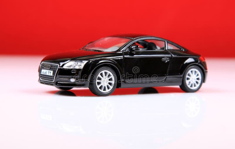 The Audi TT is a two-door compact sports car manufactured by Audi Hungaria Motor Kft. in Győr, Hungary, since 1998, for the German automaker and Volkswagen Group subsidiary AUDI AG. The Audi TT is now in its second generation — and both generations have been available in two car body styles; as a 2+2 Coupé, or two-seater Roadster. They have been built on consecutive generations of the Volkswagen Group A platform, starting with the A4 (PQ34). As a result of this platform-sharing, the Audi TT has identical powertrain and suspension layouts as its related platform-mates; this includes a front-mounted transversely orientated engine, front-wheel drive or quattro permanent four-wheel drive system, and fully independent front suspension using MacPherson struts. The Audi TT is a two-door compact sports car manufactured by Audi Hungaria Motor Kft. in Győr, Hungary, since 1998, for the German automaker and Volkswagen Group subsidiary AUDI AG. The Audi TT is now in its second generation — and both generations have been available in two car body styles; as a 2+2 Coupé, or two-seater Roadster. They have been built on consecutive generations of the Volkswagen Group A platform, starting with the A4 (PQ34). As a result of this platform-sharing, the Audi TT has identical powertrain and suspension layouts as its related platform-mates; this includes a front-mounted transversely orientated engine, front-wheel drive or quattro permanent four-wheel drive system, and fully independent front suspension using MacPherson struts.