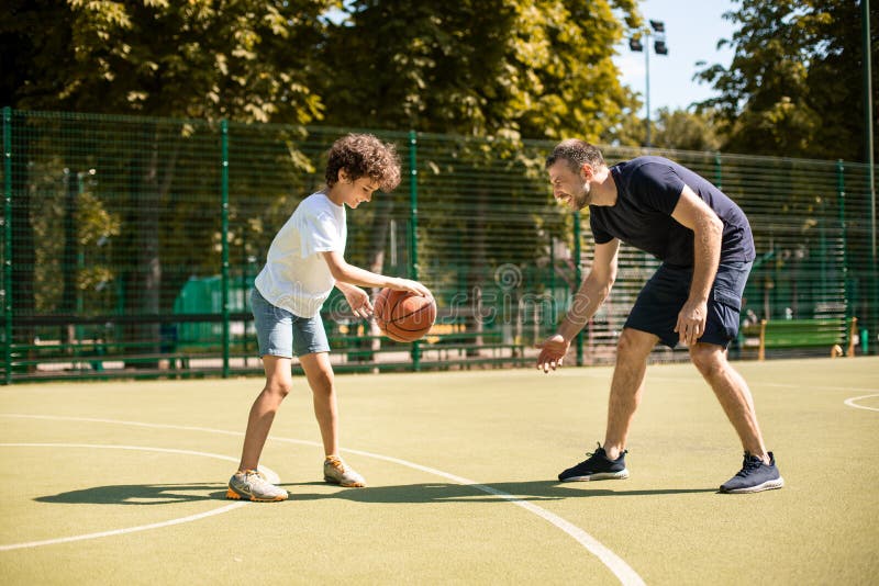 Esportivo Ensinando Garoto a Jogar Basquete Lá Fora Foto de Stock - Imagem  de atividade, objetivo: 216416036