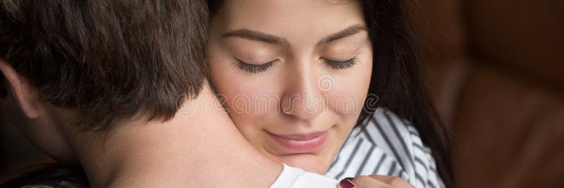 Esposa grata da cara da mulher do close up com olhos fechados que abraça o marido fotografia de stock Esposa grata da cara da mulher do close up com olhos fechados que abraça o marido fotografia de stock