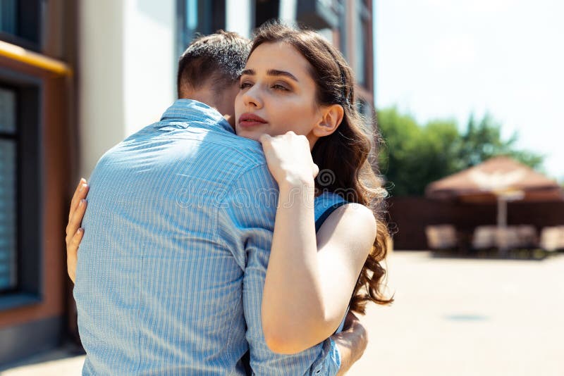 Esposa oscuro-cabelluda rizada hermosa que abraza a su hombre de apoyo imágenes de archivo libres de regalías Esposa oscuro-cabelluda rizada hermosa que abraza a su hombre de apoyo imágenes de archivo libres de regalías