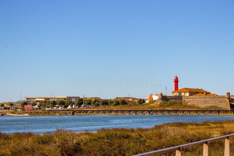 Esposende, Portugal - 10/03/2018: Scenic ocean coast with red lighthouse on background. Sunny day at sea shore in Portugal.