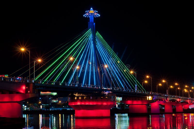 Illumination on Han River Bridge Danang with changed colors. The bridge crosses the Han River but in the middle of the night traffic is stopped from crossing it and it swings on its axis to allow shipping traffic to pass along the river. Illumination on Han River Bridge Danang with changed colors. The bridge crosses the Han River but in the middle of the night traffic is stopped from crossing it and it swings on its axis to allow shipping traffic to pass along the river.