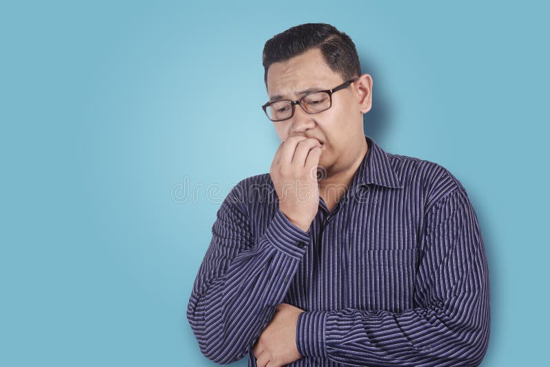 Espressione preoccupata o nervosa dell'uomo, unghie mordenti fotografia stock Espressione preoccupata o nervosa dell'uomo, unghie mordenti fotografia stock