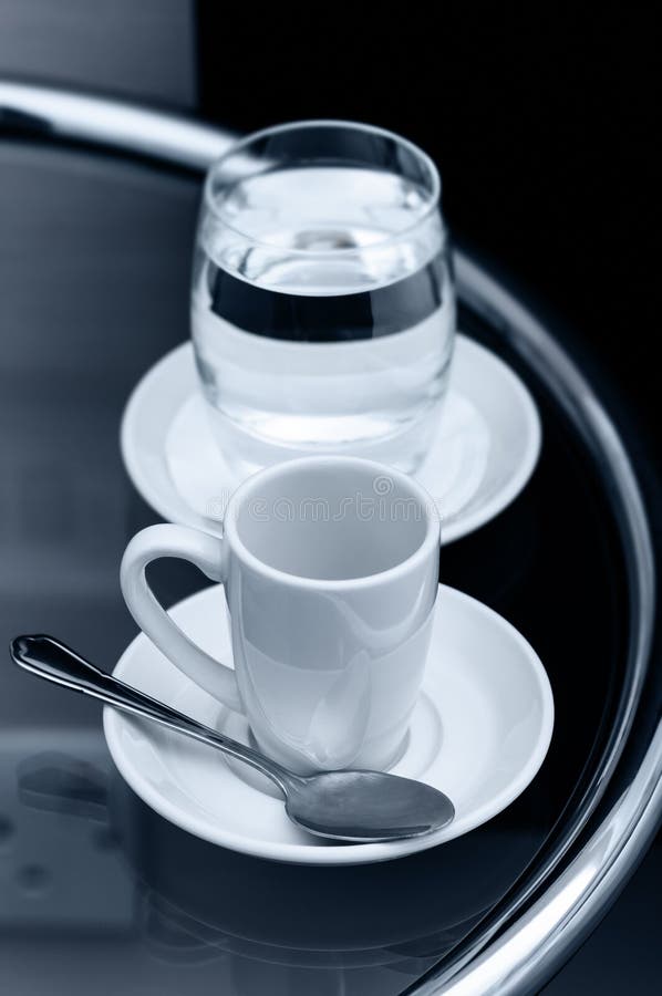 Espresso Coffee Empty Cup and Glass of Water on Bedside Table Closeup