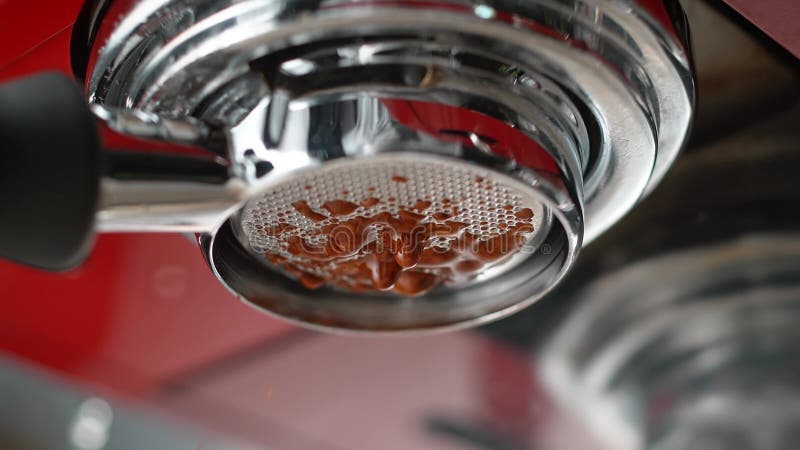 Espresso estratto da portafiltro senza fondo in un produttore di caffè rosso in slow motion