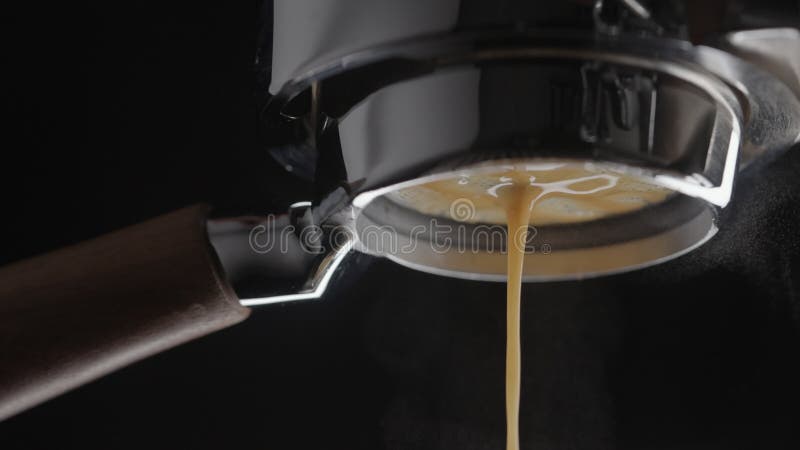 Espresso in slow motion espresso girato con portafiltro in bottiglia su una macchina da caffè professionale