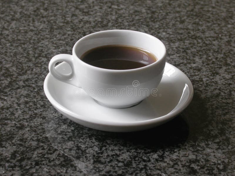 Small espresso hot cup of delicious black coffee on a black marble table top coffecup. Small espresso hot cup of delicious black coffee on a black marble table top coffecup